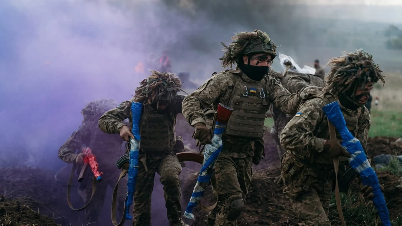 Бійці в маскувальних костюмах біжать крізь дим на польовому навчанні