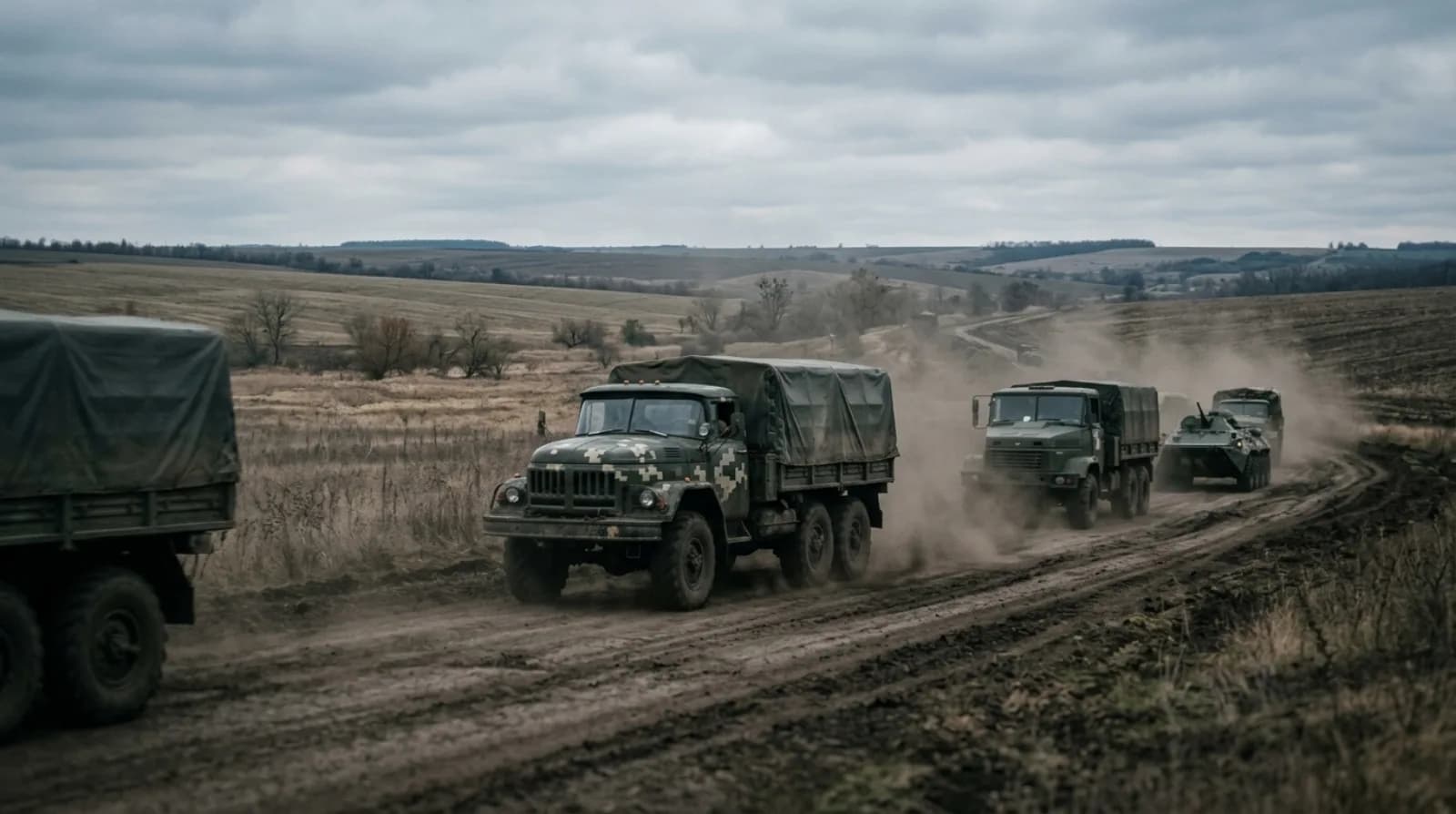 Колона військових вантажівок на польовій дорозі